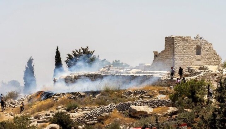 A fire burns next to the archaeological site of the ruins of the Church of St. George in the West Bank town of Taybeh. Photo: Nabd ElHaya online radio station