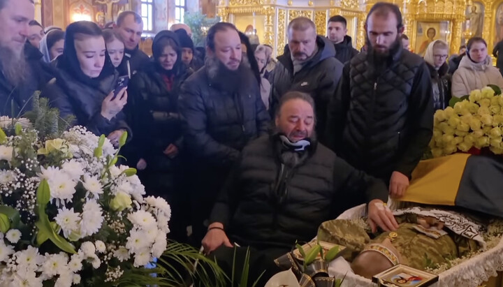 Met. Longin next to the casket of his adopted son, killed at the front. At the time, Vladyka was in a neck brace and wheelchair, after thugs had shown up to his home and beat him nearly to death.